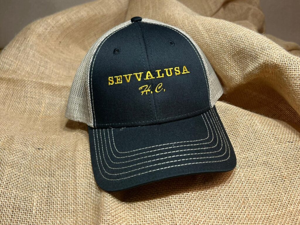 Navy and khaki trucker hat embroidered with SEVVALUSA H.C. in gold thread