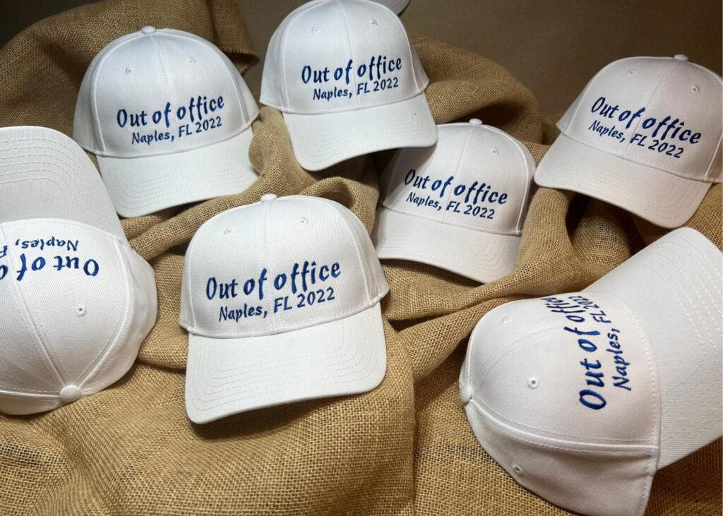 White hats embroidered with Out of Office Naples FL 2022 for a company retreat