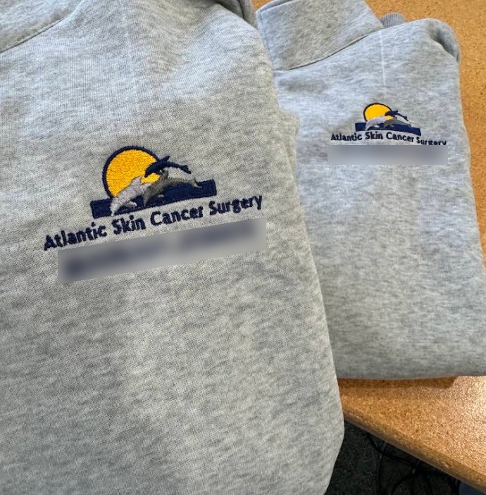 Atlantic Skin Cancer Surgery logo embroidered on gray staff sweatshirts